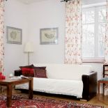 Ilustracje Eli wiszą na ścianie w salonie.