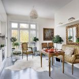 Intrygujące zestawienie: nowoczesna, oszczędna kuchnia- meble i lustro jak z pałacu. A na podłodze klepka