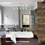 Jak przełamać chłodne szarości? Metalicznie brązowymi kaflami i fornirem brązowym jak czekolada.