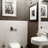 Jak w luksusowej hotelowej łazience- czarna tapeta w pałacowe wzory, kryształowe lampki i