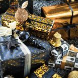 Efektowne pakowanie prezentów: papier z brokatem i wyszukane wzory, na przykład w panterka lub pawie pióra.