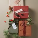 Do ozdobienia prezentu możesz wykorzystać gałązki z czerwonymi owocami dzikiej róży i szyszki.