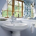 Jasna łazienka z dekoracyjnymi zasłonami.