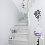 Jasno urządzone wnętrze, z kominkiem, ogromnymi oknami i drewnianym tarasem.