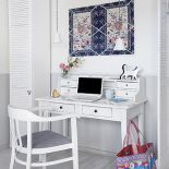 Jasno urządzone wnętrze, z kominkiem, ogromnymi oknami i drewnianym tarasem.