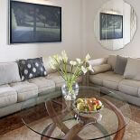 Jedwabisty perski ręcznie tkany dywan w perłowo-gołębim odcieniu i beżowe włoskie kanapy firmy Polaris z