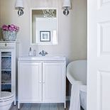 Joanna uważa, że kafelki nie są eleganckie, dlatego ściany pomalowała, a na podłodze położyła drewno.