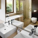 Kapiel w towarzystwie świerków? Jakie to miłe. Łazienka wydaje się większa dzięki olbrzymim oknom i lustrom.