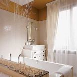 Kąpielowa część sypialni jest bardzo kobieca. Delikatny ornament na glazurze, niczym ze starej tapety, czarodziejska