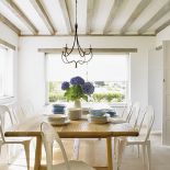 Klimat prowansalskiej jadalni uzyskano dzięki pięknemu, drewnianemu stołowi i metalowym krzesłom.