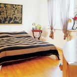 Kobieca sypialnia urządzona w ciepłych kolorach.