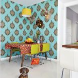 Kolorowe dodatki: turkusowa tapeta, limonkowe krzesła, soczyste odcienie na tkaninach.