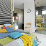 KOlorowe tkaniny rozweselają betonowe ściany.