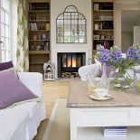 Kominek w salonie. Styl prowansalski: biała willa nad stawem