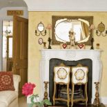 Kominek zbudowany w latach trzydziestych zasłonięty jest ręcznie malowanym parawanem.