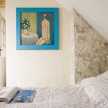 Koronkowa kapa na łóżku i rodzinne graffiti na ścianie.