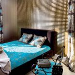 Kratkę na ścianie sypialni trudno było oswoić . Pomogły turkusy i kwiaty.