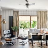 Królem w salonie jest Lounge Chair Eamesów, obok kultowego fotela stoi dizajnerska dębowa lampa z