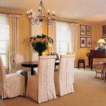 Krzesła ubrane w eleganckie pokrowce.