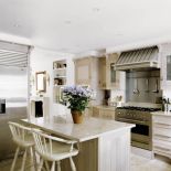 Kuchenne szafki zrobiono z bielonej dębiny, a blaty z piaskowca. Dla kontrastu, w jadalni obok