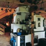 Kuchnie węglową otacza kolekcja starych naczyń.