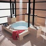 Łazienka w japońskim stylu. Nad okrągłą wanną zamontowano panel prysznicowy. Płytki z kolekcji Navona (30 x 60 cm) kosztują