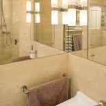 Łazienka wykończona jasnym kamieniem.