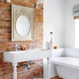 Łazienkę właściciele wymyślili sami - postawili ścianę z cegieł, ktora, choć nowa, udaje starą. Nogi do umywalki to pomysł