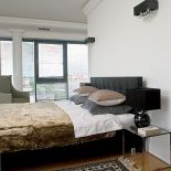 Lniane zasłony, kanapy i dywan w ekologicznych kolorach, szlachetny kamień. To przepis na włoskie mieszkanie w Warszawie.