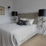 Łóżko Margaret od Decolor z tapicerowanym zagłówkiem. Po obu stronach dość masywna lampy w stylu glamour.