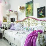 Łóżko ubrane na cebulkę (poduszki i narzuty są z Arte Ego). W całym domu zobaczymy kryształowe kinkiety i żyrandole,