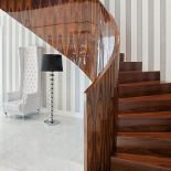 Lśniący lekko czerwonawy brązem palisander ociepla graficzne biało-czarne monumentalne wnętrze.