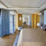 Sypialni przytulności dodają tkaniny i kolory – beże, błękity i szarości zestawione z żółtymi zasłonami.