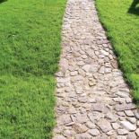 Łupany kamień polny ułożono na żwirze. KONGO OGRODY