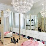 Lustra na tyłach francuskich szaf i awangardowe bąbelkowe lampy Puff-Buff kontrastują ze stylowym tłem. Garderoba