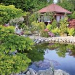 Mała altanka komponuje się z otaczającymi ją roślinami.