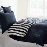 Marka Grand Design, pościel w granatowe i białe pasy Jersey Stripe Navy, od 465 zł, oraz Oxford z logo