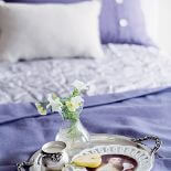 Matowo i z połyskiem: lniana narzuta i poduszki oraz satynowa kapa i wełniany pled z NAP.