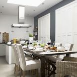 Metalowy stół Brooklyn z blatem z postarzanego drewna – od 7050 zł. Krzesła Cape Breton z haczykiem na