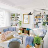 DUŻO LUSTER – NA KOMINKU, NA ŚCIANACH REGAŁU I FILARZE – ROZŚWIETLAJĄ I POWIĘKSZAJĄ OPTYCZNIE SALON.