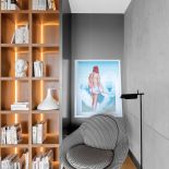 Podświetlona biblioteka nie tylko ładnie wygląda, sprawia też, że w lofcie robi się przytulniej. Fotel