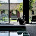 Minimalistyczny basen zdobi... sielski widok za oknem.