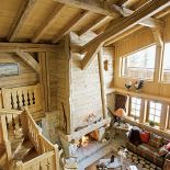 Miodowy odcień drewna, grube pledy i poduszki, abażury w słonecznych kolorach, skórzany fotel - ma być przytulnie i jasno.