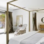 Mniej znaczy więcej. Proste łóżko z baldachimem, wiklinowe fotele i obrazy oparte o ścianę. I tak widoki są tu najważniejsze.