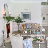 Na kominku prosty, ale efektownie wyglądający stroik z gałązek świerkowych.