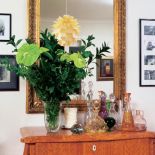 Na komodzie stoi kolekcja karafek. Sposób na antyki