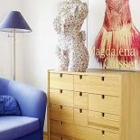 Na komodzie stoi ubrany manekin. Kobieta i lampy