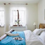 Na łóżku w sypialni leży lazurowa narzuta - to z tęsknoty za lazurem wody.