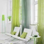 Na oknach subtelne firanki z tkaniny Akira w cenie 191 zł. Seledynowy materiał na poduszki - 308 zł/m.b. DEKOMA