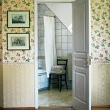 Na ścianach lamperia, a nad nią kremowa tapeta z kwietnym wzorem.